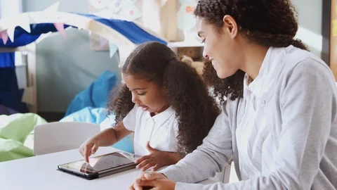 Young black schoolgirl using a tablet computer and learning one on one with Stock Footage 102369469