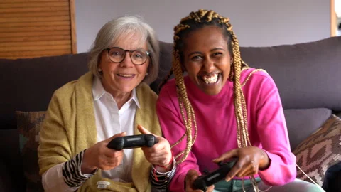 Young black woman next to an older woman playing a console game Stock Footage