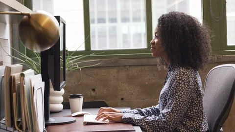 Young black woman using computer in an office, side view Stock Footage 86611690