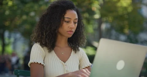 Young black woman using working on laptop computer in a park 8k Vídeos de archivo 254405911
