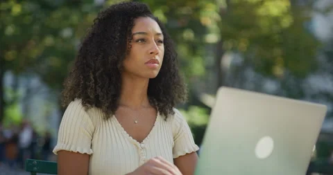 Young black woman using working on laptop computer in a park 8k Vídeos de archivo 254416543