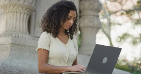 Young black woman using working on laptop computer in a park 8k Vídeos de archivo 254433693
