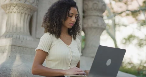 Young black woman using working on laptop computer in a park 8k Vídeos de archivo 254434390