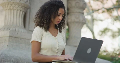 Young black woman using working on laptop computer in a park 8k Vídeos de archivo 254434516