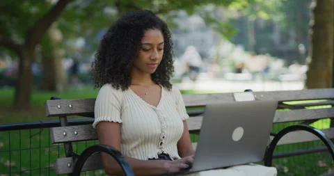 Young black woman using working on laptop computer in a park 8k Vídeos de archivo 254447774