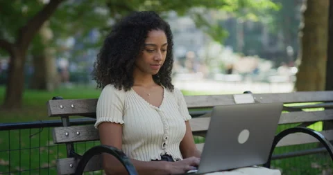 Young black woman using working on laptop computer in a park 8k Vídeos de archivo 254449375