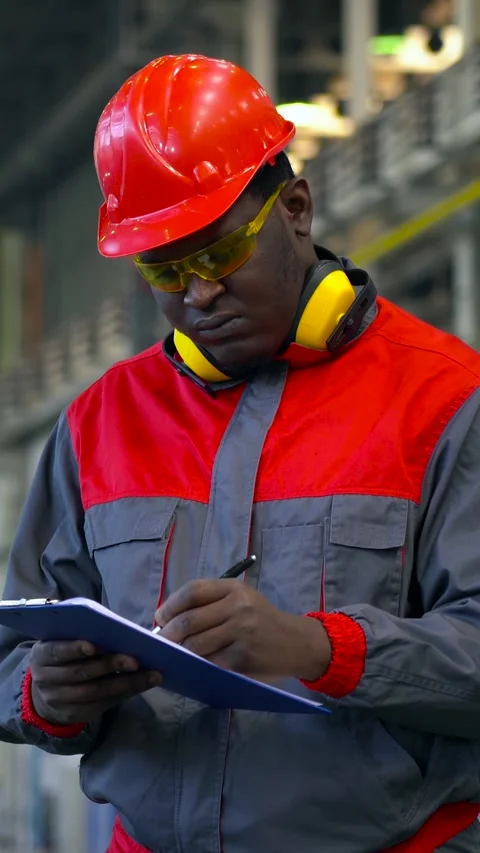 Young Black Worker in Personal Protective Equipment Writes on Clipboard Stock Footage 312734299