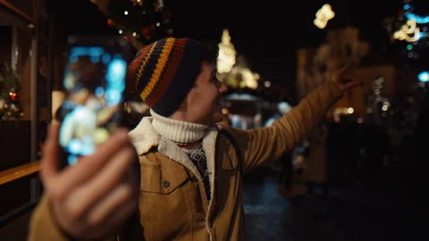 Young Blogger record himself on phone at night on a busy street on Christmas and Stock Footage 218302916