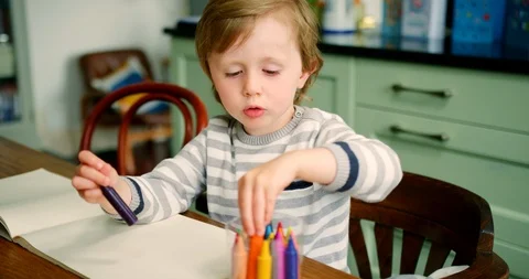 Young Blond Boy Putting Crayons Into Plastic Container Stock Footage 100042769