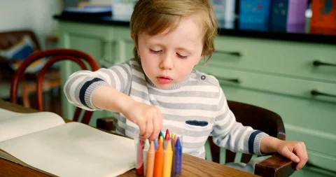 Young Blond Boy Putting Crayons Into Plastic Container Stock Footage 100042779