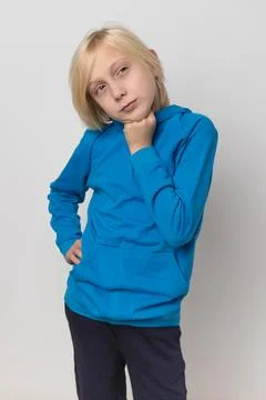 Young blond boy with a thoughtful expression posing against a clean white b.. Foto stock