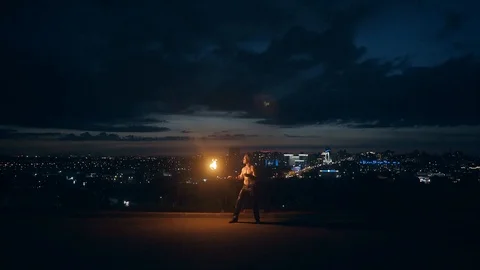 Young blond male does tricks with fire, Male breaths out large stream of fire Stock Footage 105213664