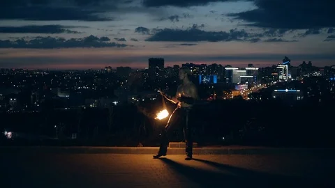Young blond male does tricks with fire, breaths fire in the middle of the night Stock Footage 105219067