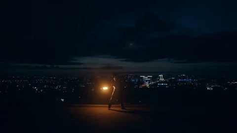 Young blond male does tricks with fire, breaths fire in the middle of the night Vídeo Stock 105219403