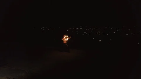 Young blond male does tricks with fire, spins two burning torches at night on Stock Footage 105220608