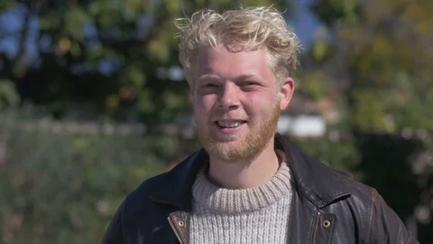 A young blond man with a beard laughing and smiling at the camera Stock Footage 72363941
