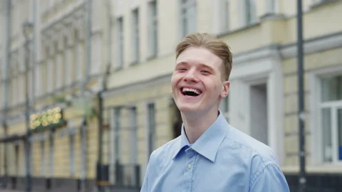 Young blond man feeling happy and laughing at camera Stock Footage 219533586