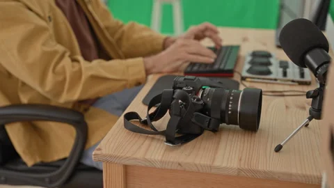 Young blond man typing with both hands on keyboard beside dslr camera, lens.. Stock Footage 339194213