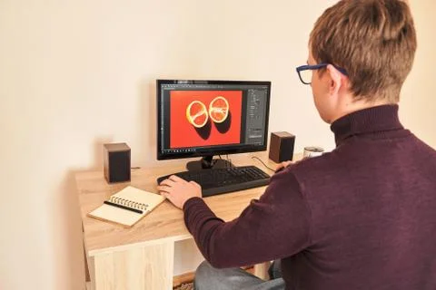 Young blond millennial working at computer drinking coffee at home Stock-Fotos
