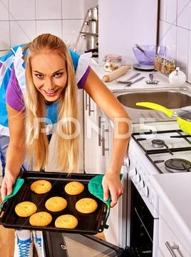 Young blond smiling woman bake cookies. Stock Photos