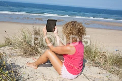 Young blond woman make selfie at the beach. Stock Photos