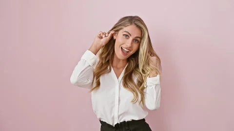 Young blonde bombshell in pink, pulling a crazy face - finger in ear giggle.. Stock Footage 263463431