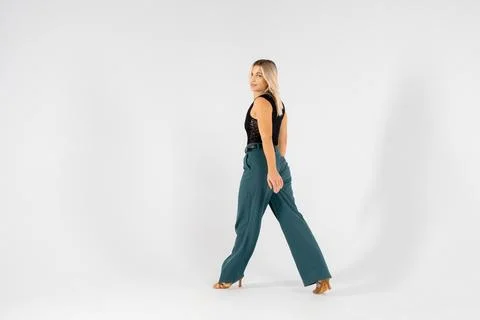 Young blonde dancer posing with hands joined and legs apart on white backgrou Stock Photos