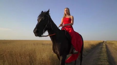 Young blonde girl horseback rider in red... Stock Video Pond5