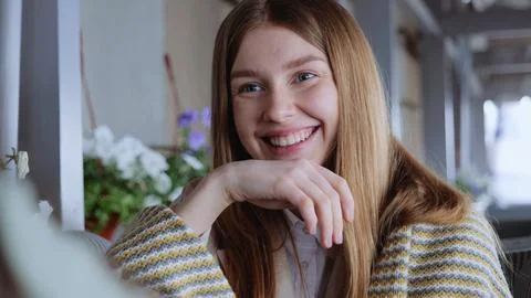 Young blonde girl smiling while sitting in a cafe. A young woman in a cafe Stock Photos