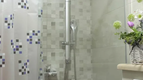 A young blonde in a glass shower sets th... | Stock Video | Pond5
