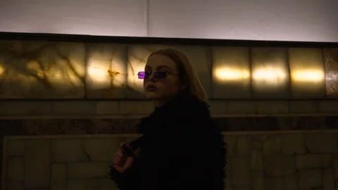 Young blonde in glasses posing in front of the camera at the subway station. Stock Footage 114295685