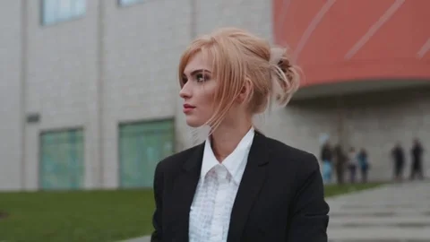 Young blonde-haired self confident woman with red lips walking out of the office Video stock 74696601