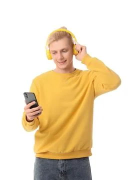 Young blonde man in headphones using mobile phone on white background Stock Photos