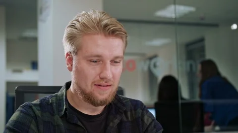 A Young Blonde Man Working in an Office Stock Footage 86335055