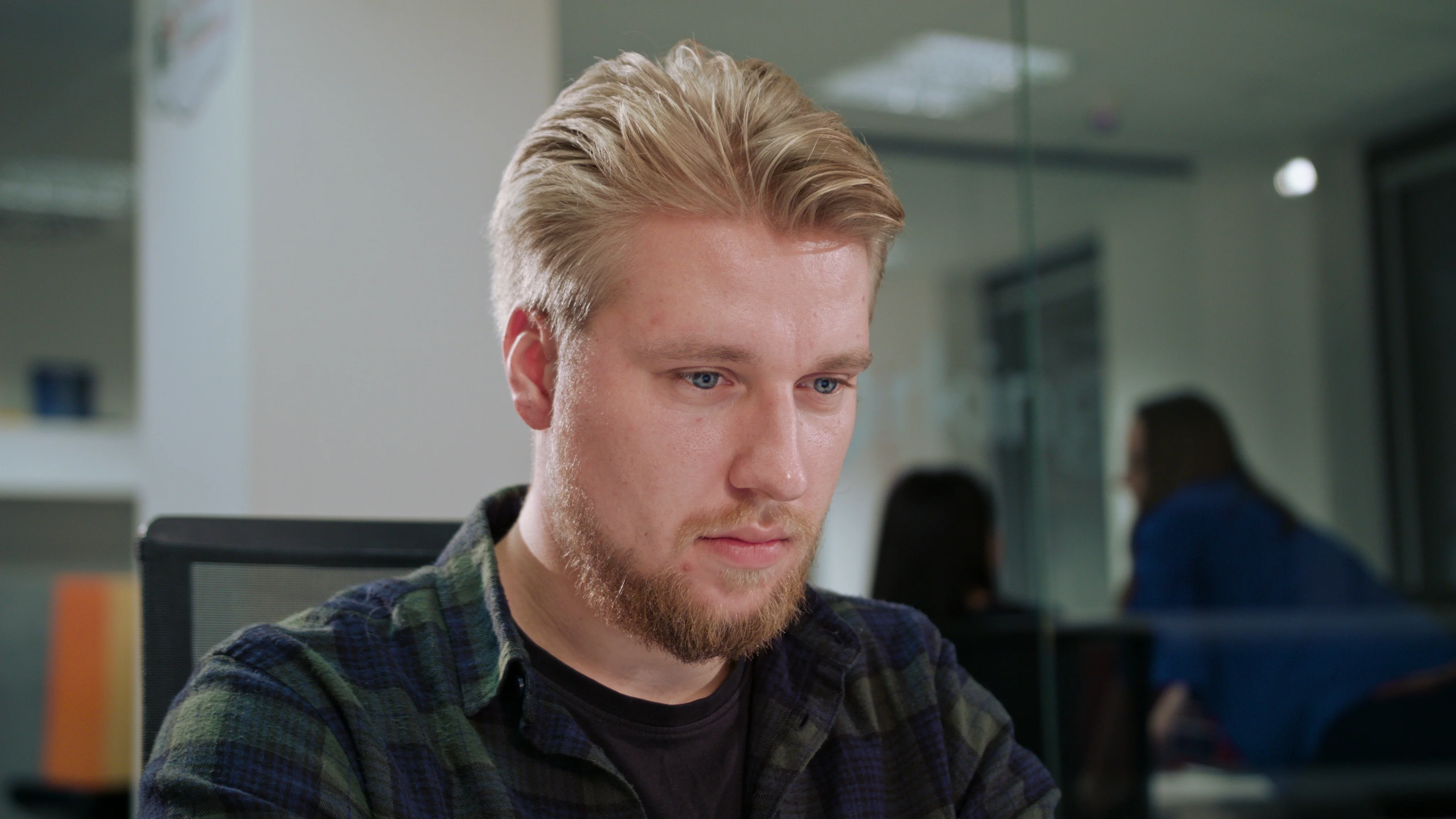 A Young Blonde Man Working in an Office