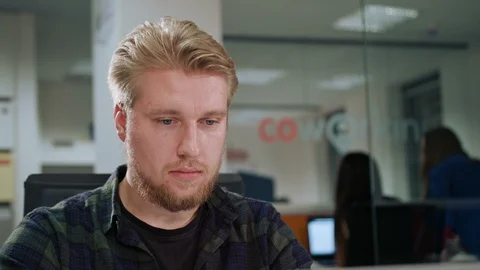 A Young Blonde Man Working in an Office Stock Footage 86338761