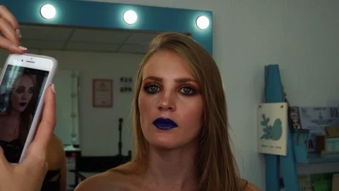 Young blonde model wearing blue lipstick and bright colors total festive makeup Stock Footage 102735154