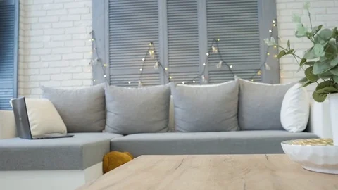 Young blonde puts the mug on the table and lay down on the sofa with a 스톡 동영상 102735016