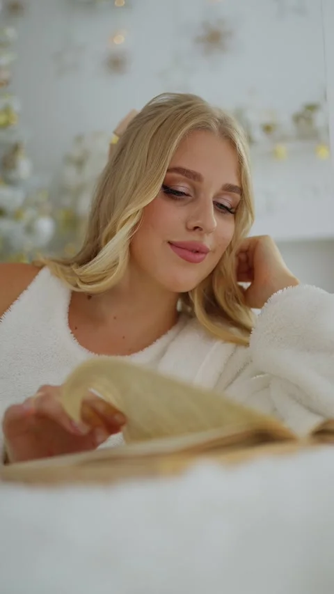 A young blonde is reading a book Stock Footage 253749952
