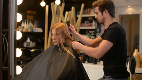 Young blonde woman having a new hairstyle Stock Footage