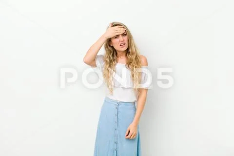 Young blonde woman panicking over a forgotten deadline, feeling stressed, hav Stock Photos