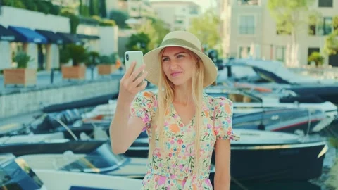 Young blonde woman taking selfie at urban marina with yachts Vídeos de archivo 342797953