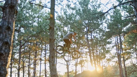 Young bmx rider doing various 360 air tricks on a set of trail jumps. Stock Footage 92080984