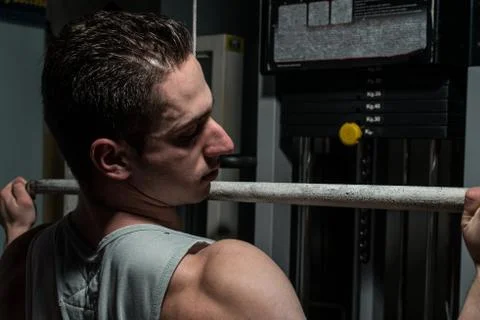 Young body builder doing heavy weight exercise for back Stock Photos