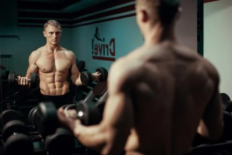 Young bodybuilder man doing exercise dumbbell Stock Photos