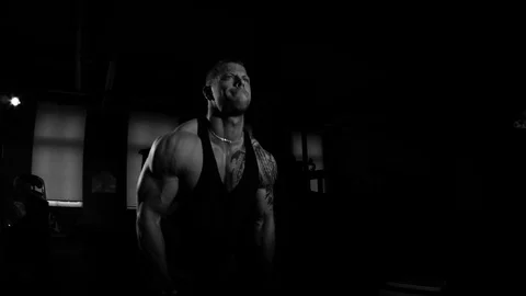 Young bodybuilder training in a gym. Dramatic black and white footage Stock Footage 74313179