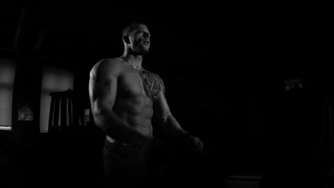Young bodybuilder training in a gym. Dramatic black and white footage Stock Footage 74313235