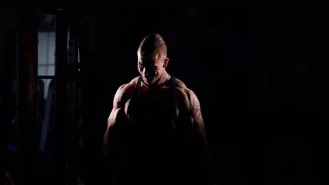 Young bodybuilder training in a gym with dumbbels. 60 to 24fps 4K Vídeo Stock 74338216