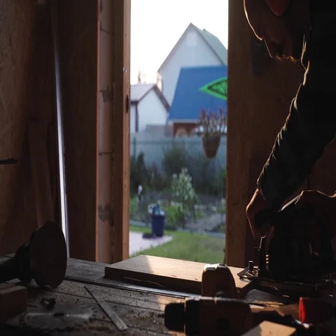 Young bold carpenter with moustache. circular saw cutting piece of wood. sun Stock Footage 69539782