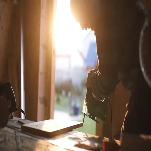 Young bold carpenter with moustache. circular saw cutting piece of wood. sun Stock Footage 69540366